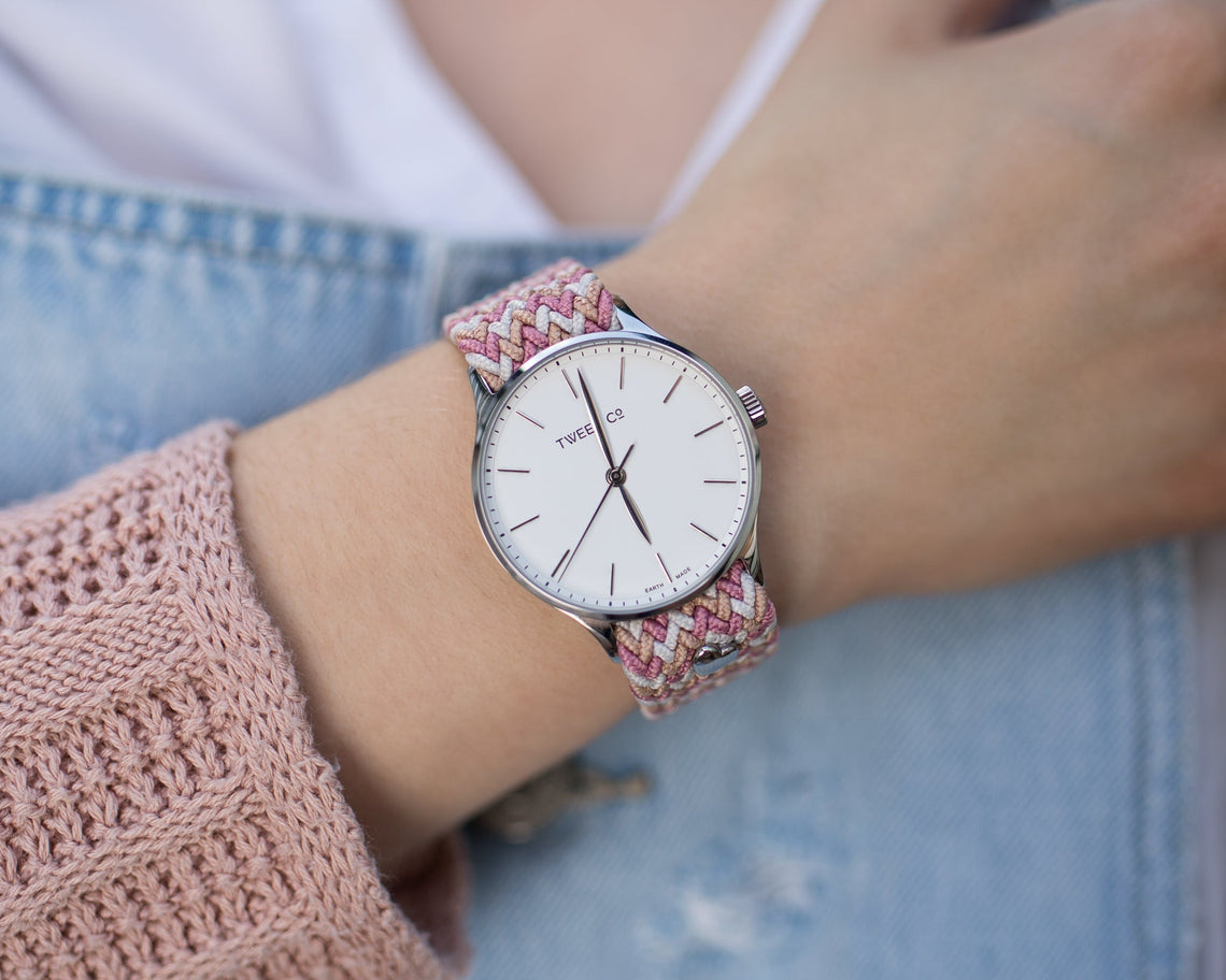 Montre femme Tweed Co. en or rose avec bracelet rose et blanc portée au poignet, alliant raffinement et personnalisation.